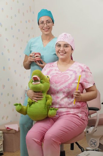 Dra. Karla y Dra. Edith con cocodrilo didáctico y cepillo infantil